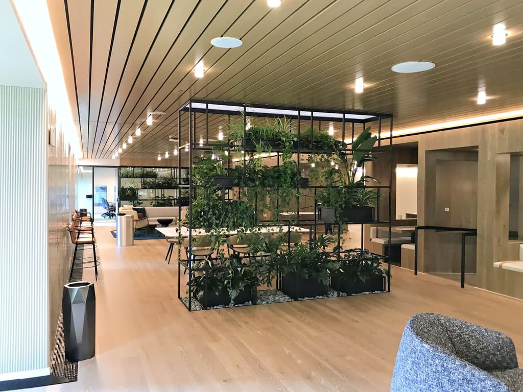 Lounge with a wood slat ceiling and a planted shelving wall